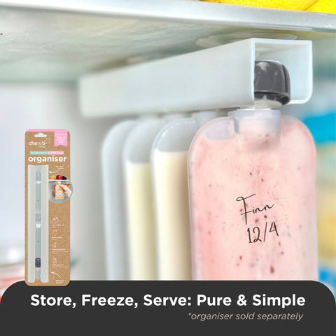 A refrigerator organizer bottle holder shown mounted on a fridge shelf, holding several translucent storage bottles. One bottle in front contains a pink drink and is labeled 'Finn 12/4' in black marker.