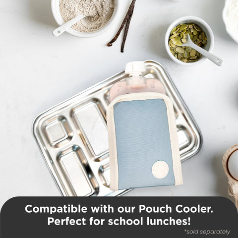 A reusable pouch cooler in a light blue and cream fabric sleeve, shown holding a pink bottle on a compartment metal tray. Small bowls of food ingredients are arranged around it on a white surface, with a text banner at the bottom stating compatibility with a pouch cooler for school lunches.