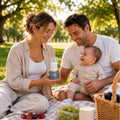Parents enjoying a picnic with their baby outdoors while using a portable bottle warmer V3 to prepare a bottle.