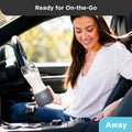 Mother in a car holding a portable bottle warmer V3 with a baby bottle, ready for feeding on the go.